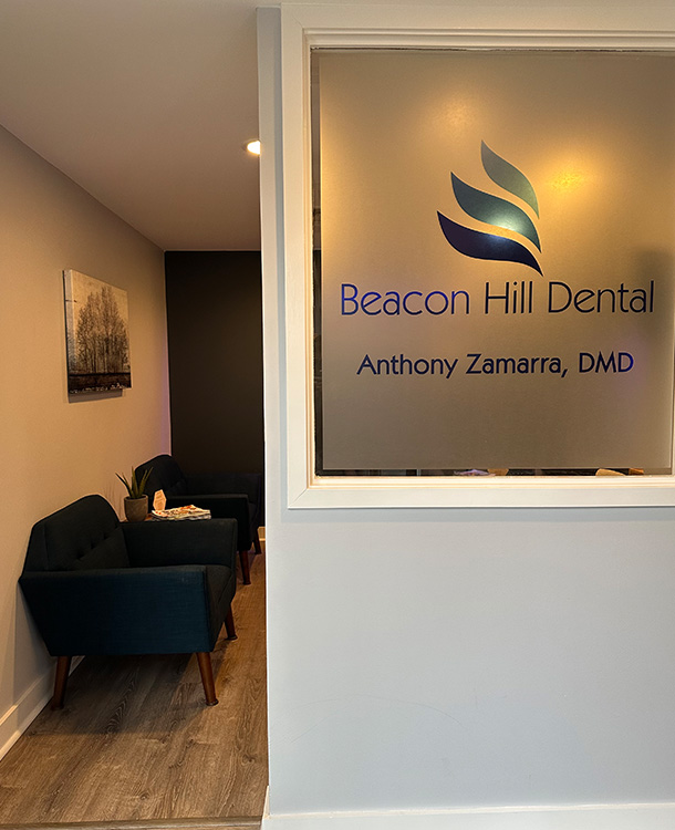 The image shows an interior view of a dental practice, featuring a reception area with a window displaying the name  Beacon Hill Dental  and the logo of a stylized blue bird.