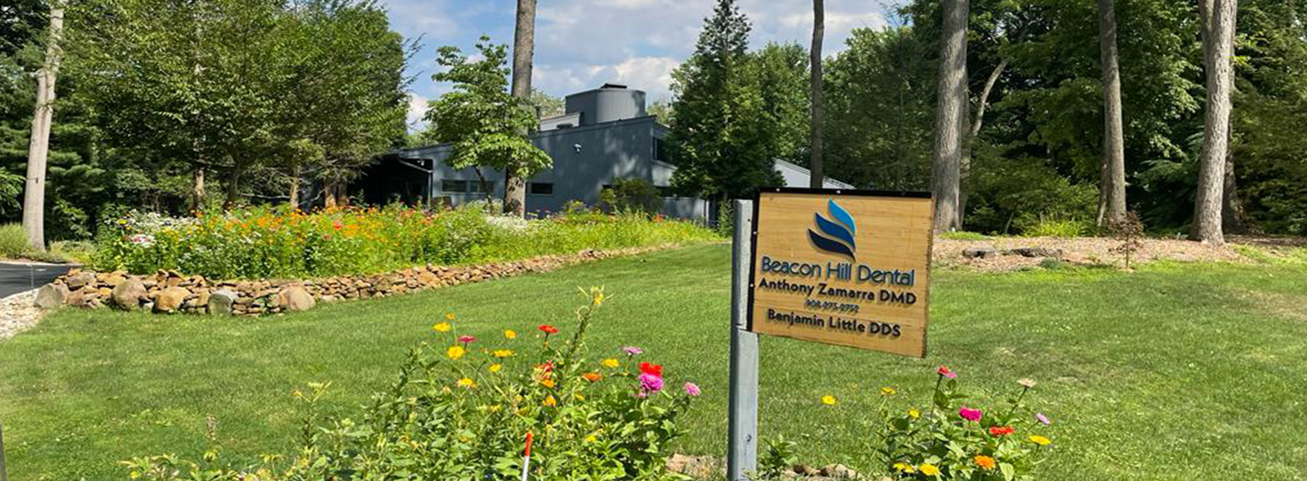 The image shows a sign with text that reads  Woodland Beach Golf Club  placed in a grassy area with trees and shrubs, indicating the location of a golf club.