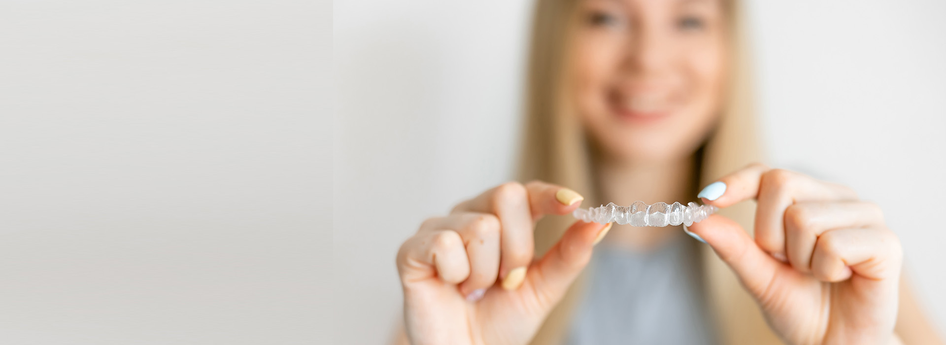 A woman holding a ring in her hand against a blurred background.